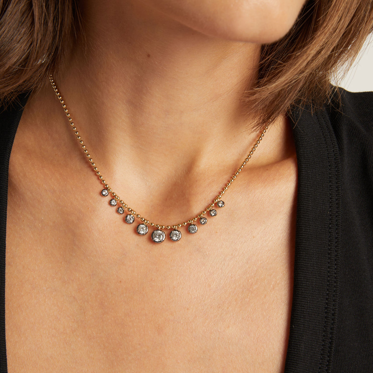 Model. Close up of woman wearing a Graduated Georgian Chain Necklace on neutral background.