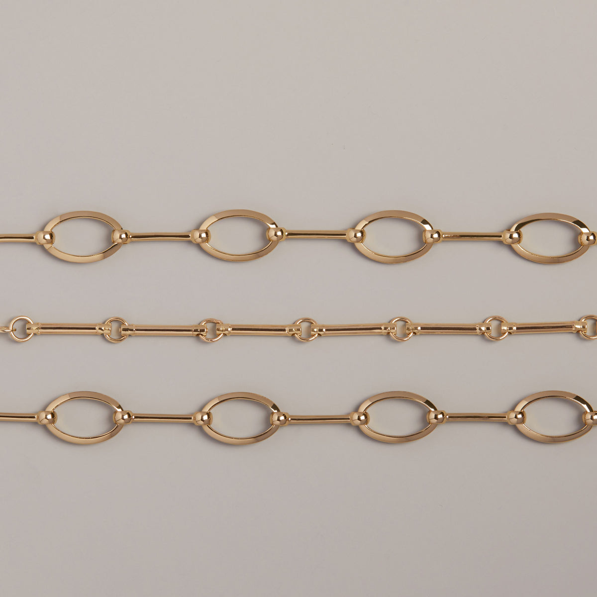 Model. Three gold chains on a neutral background