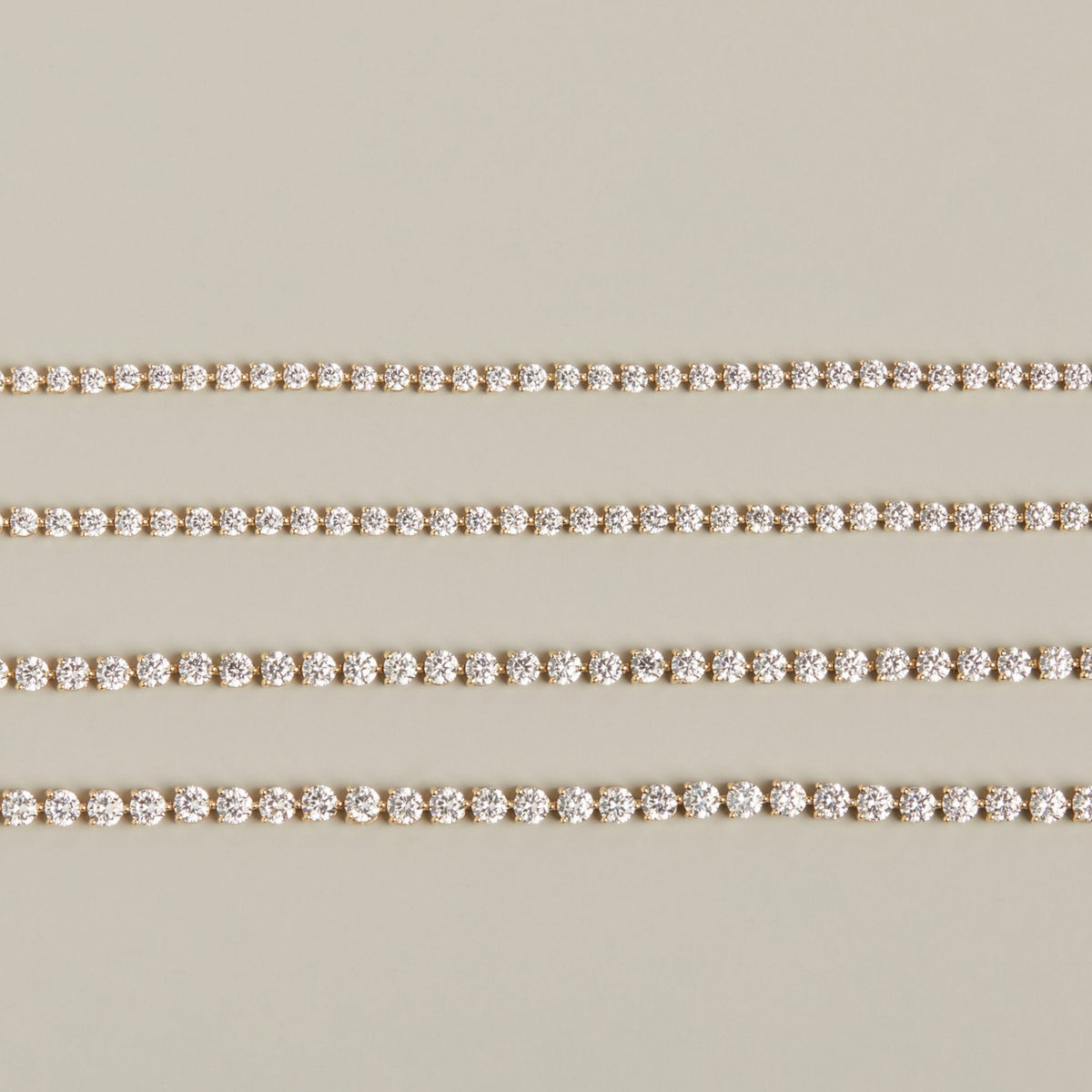 Model. Four diamond tennis bracelets on neutral background