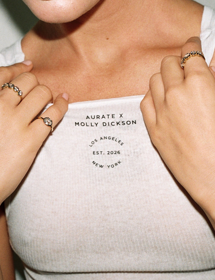 Model. Close up of woman wearing white tank top with lots of jewelry on.