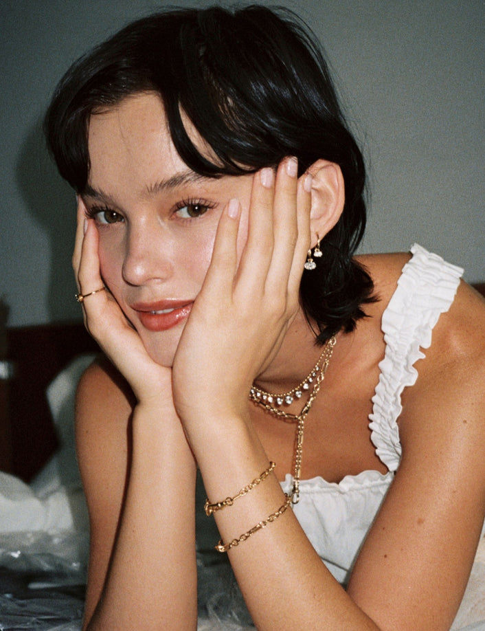 Model. Close up of woman with her head in her hands wearing various jewelry
