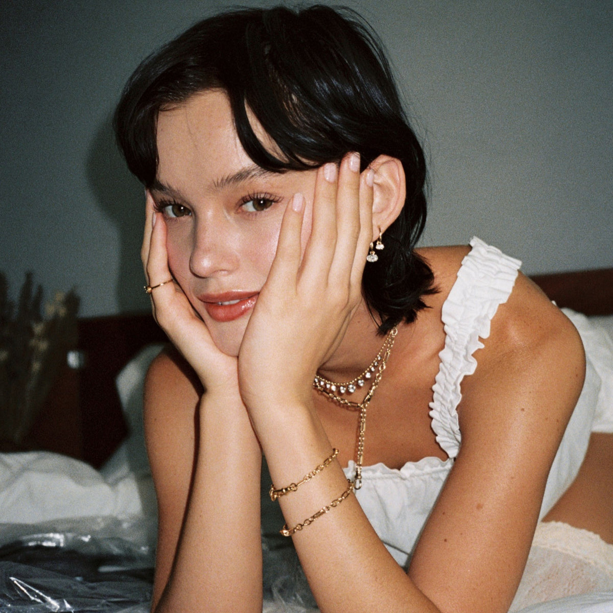 Model. Close up of woman with her head in her hands wearing various jewelry
