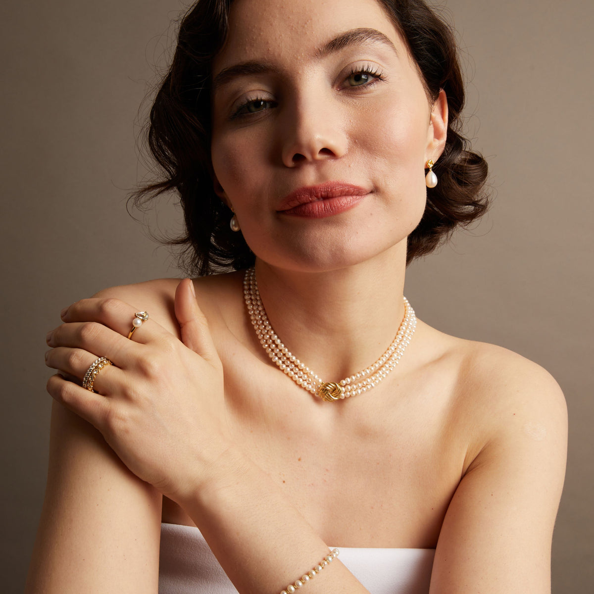 Pearl necklace on woman with neutral background. 