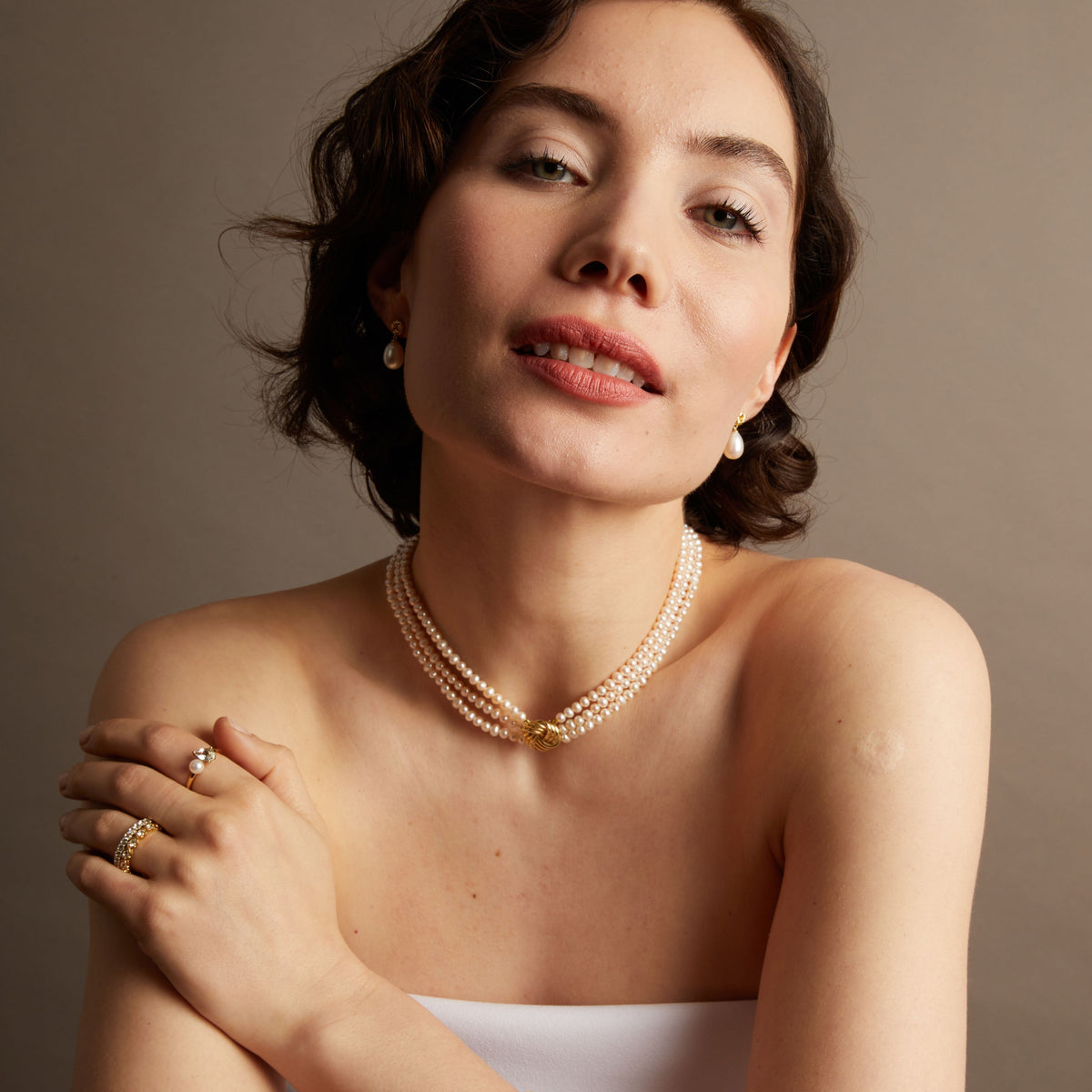 Pearl necklace on woman with neutral background. 
