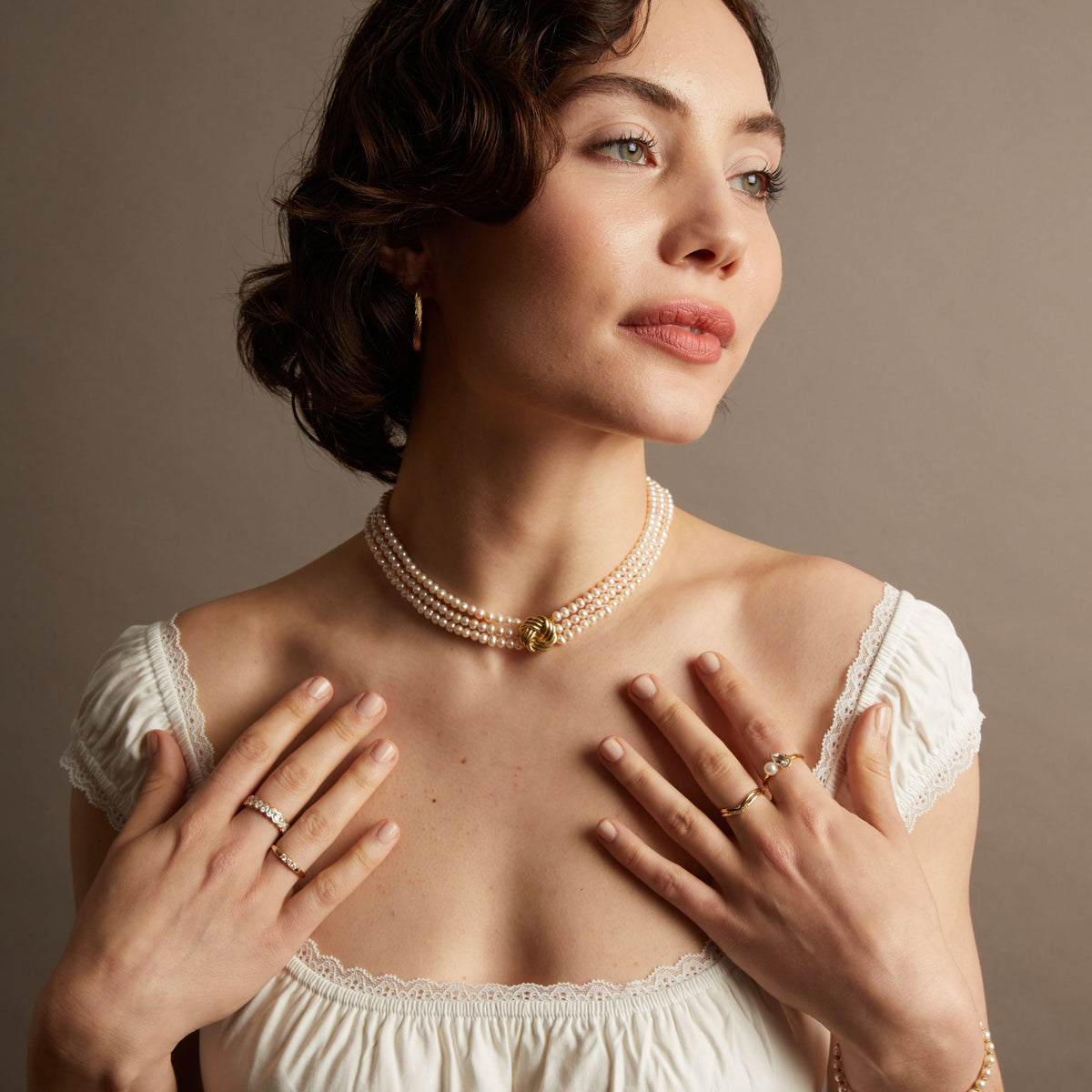Pearl necklace on woman with neutral background. 