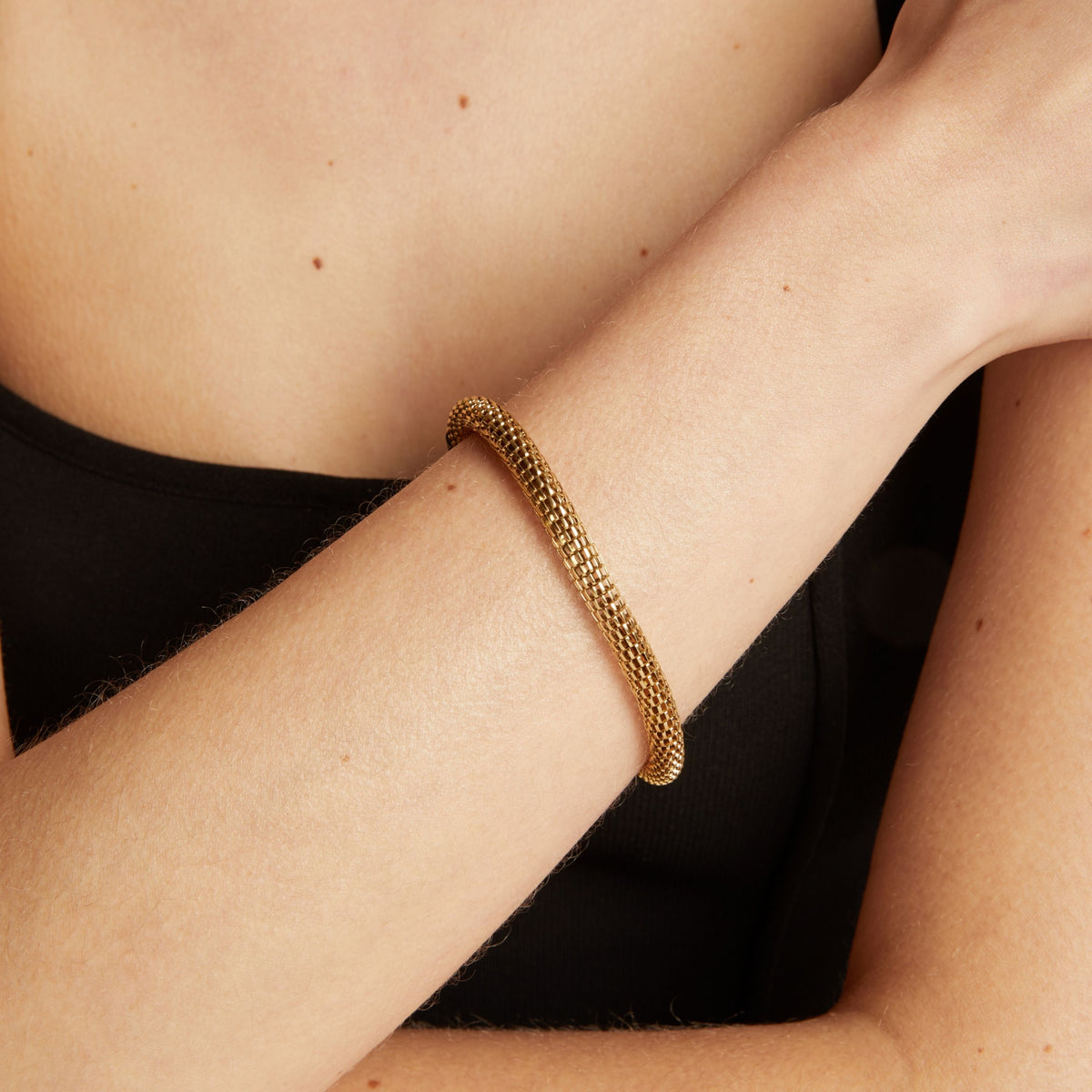 Gold chain bracelet on wrist. 