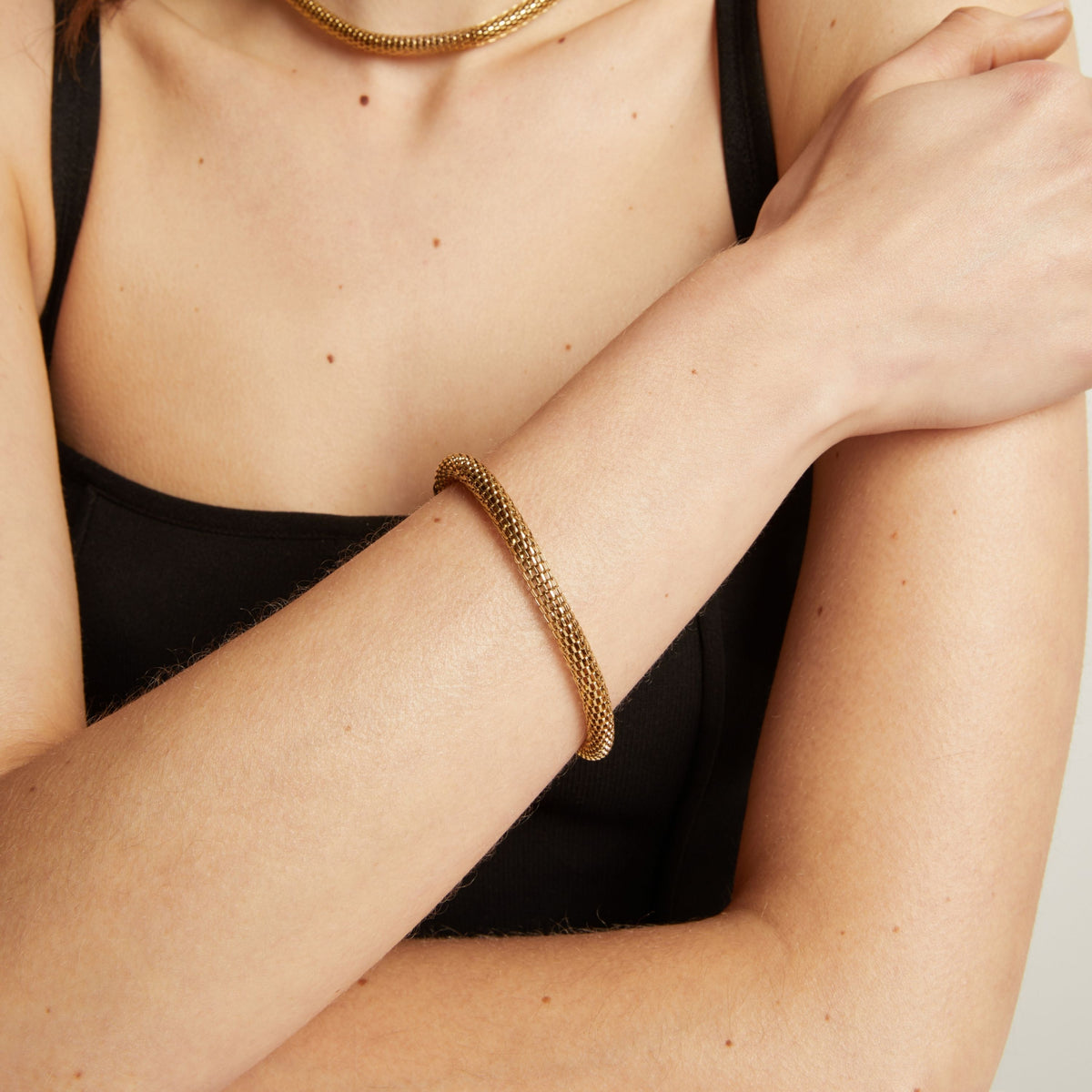 Gold chain bracelet on wrist.
