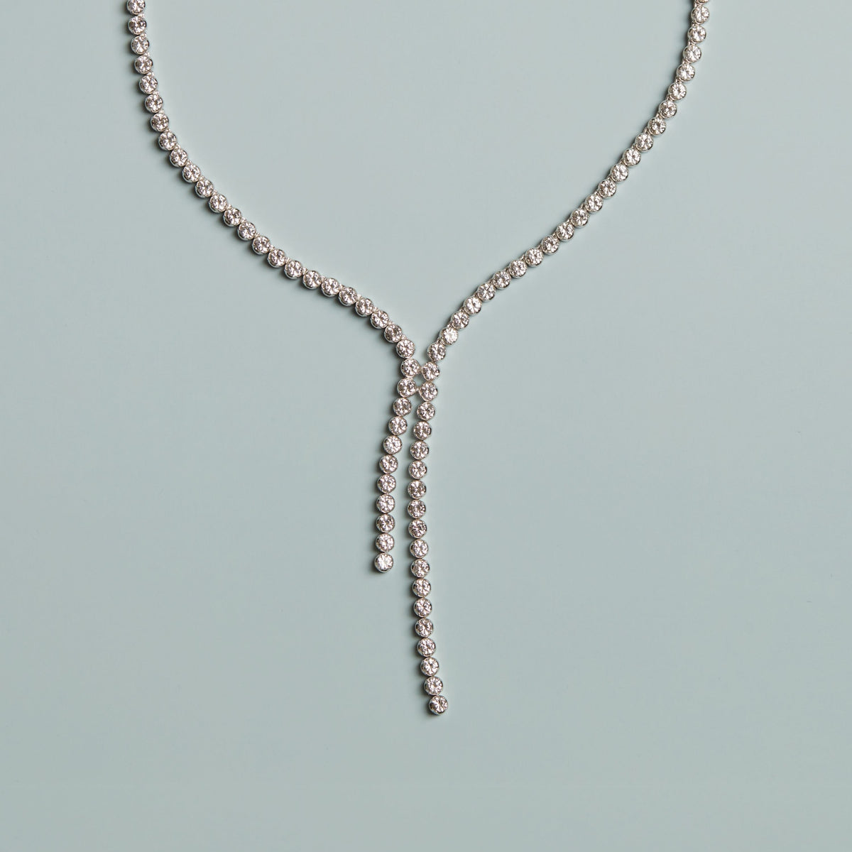 Diamond necklace on a light blue background. Model.