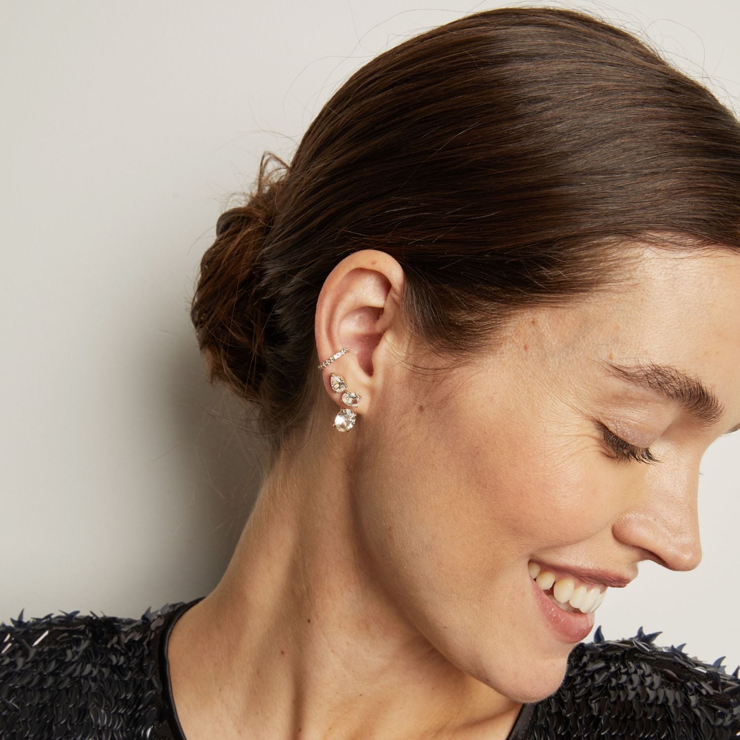 Model. Close-up of a woman wearing earrings with a neutral background