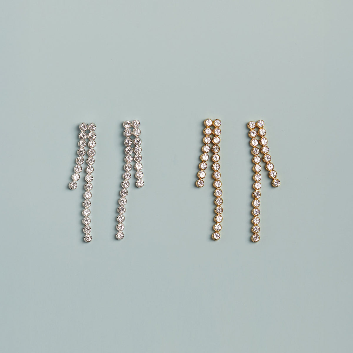 Model. Diamond tennis earrings on blue background.