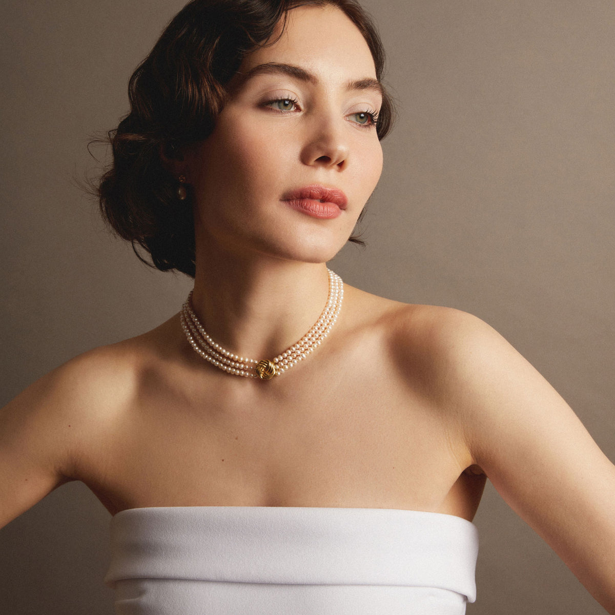 Pearl necklace on woman with neutral background. Model