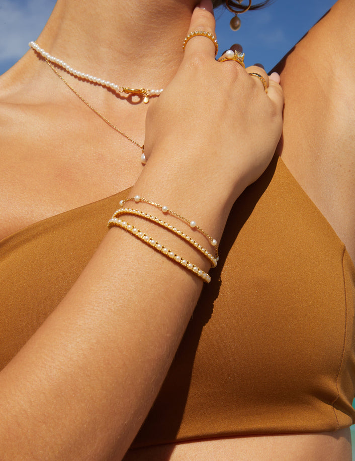Model.  close up of woman wearing bracelets and rings on the beach 