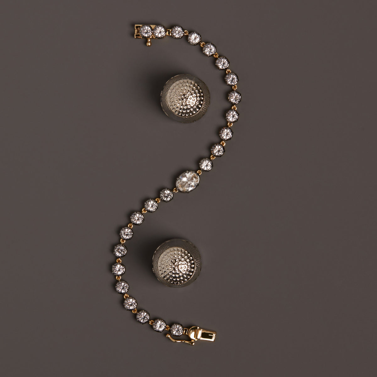 Model. Close up of gemstone tennis bracelet on brown background.