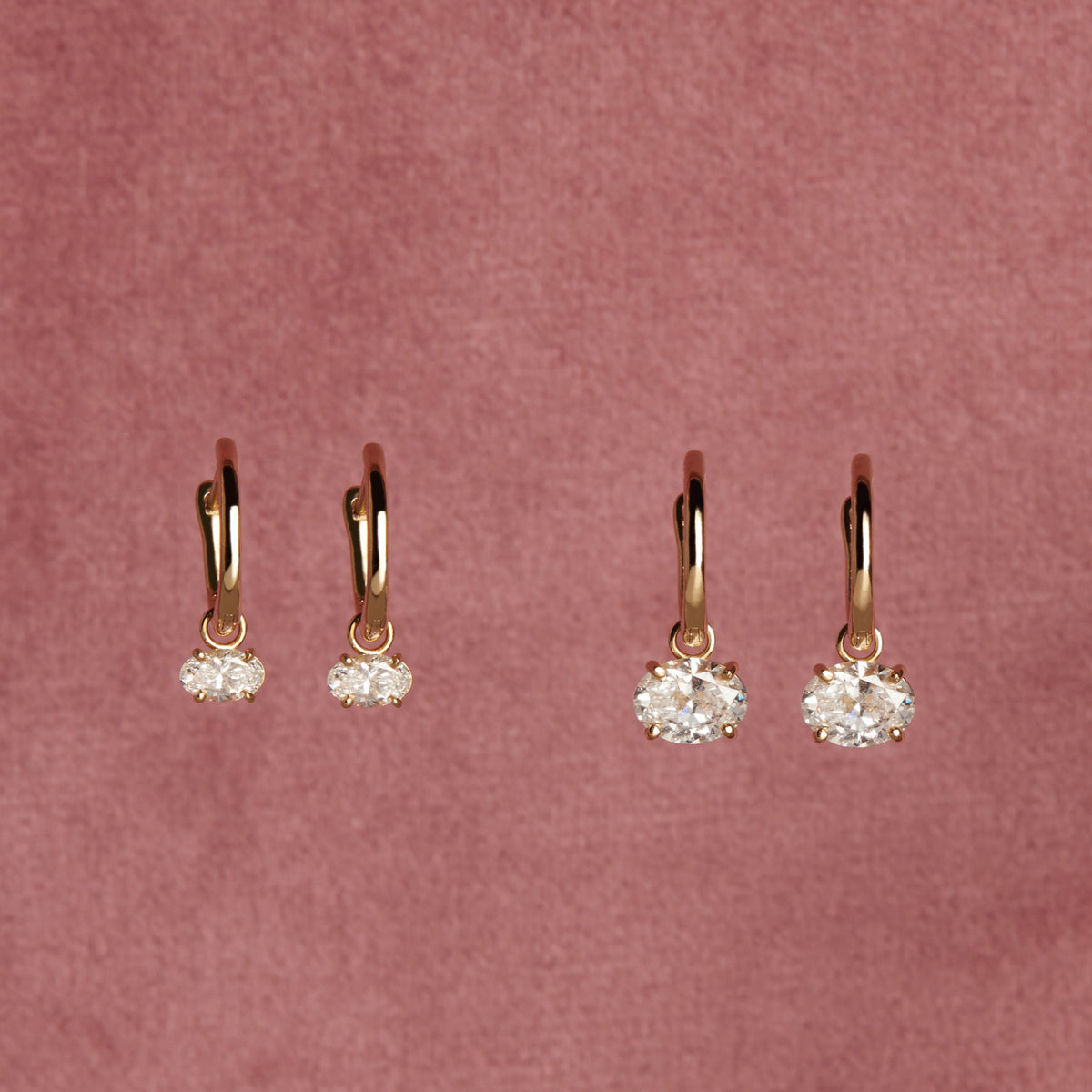 Model. Close up of diamond drop earrings on pink background. 