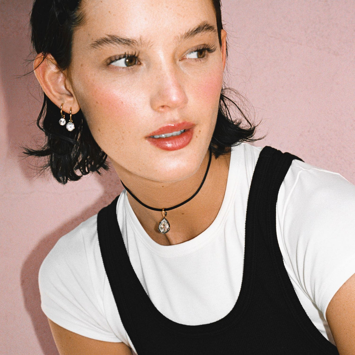 Model. Close up of woman wearing a Pear Georgian Pendant on a black nylon cord on pink background