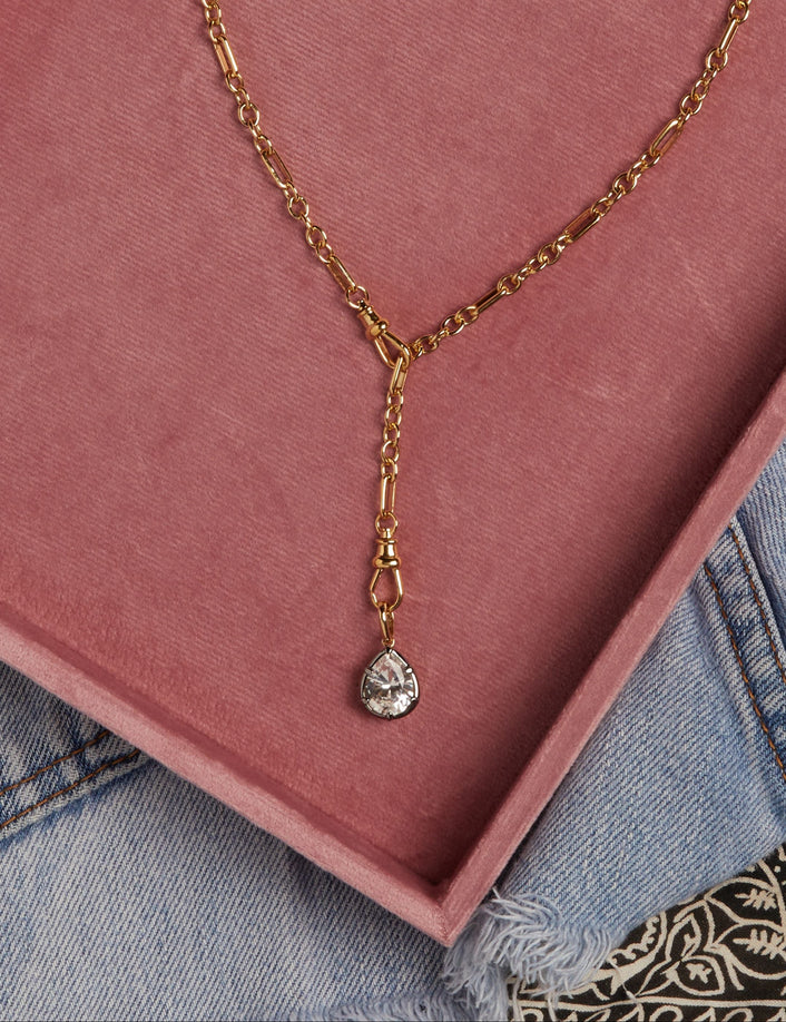 Model. Close up of gold chain necklace in pink box