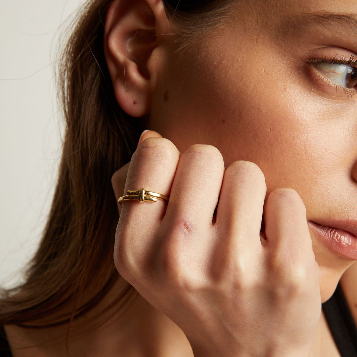 Close up of a person wearing a gold ring on their finger.