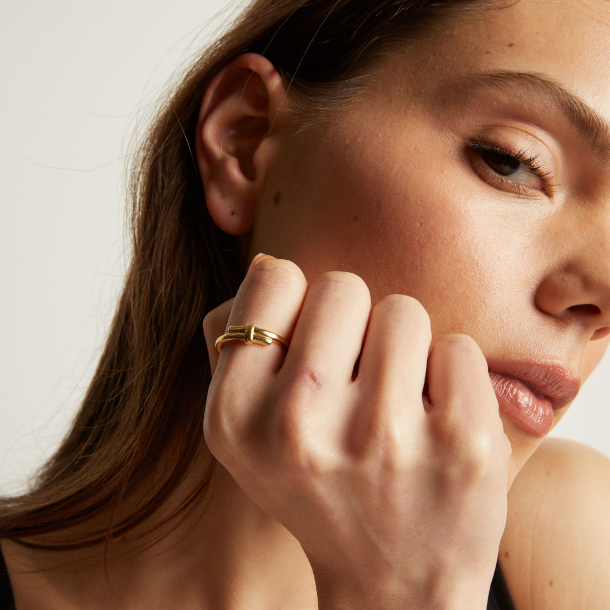 Close up of a person wearing a gold ring on their finger.