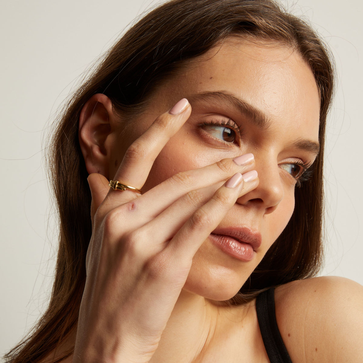 Close up of a person wearing a gold ring on their finger.
