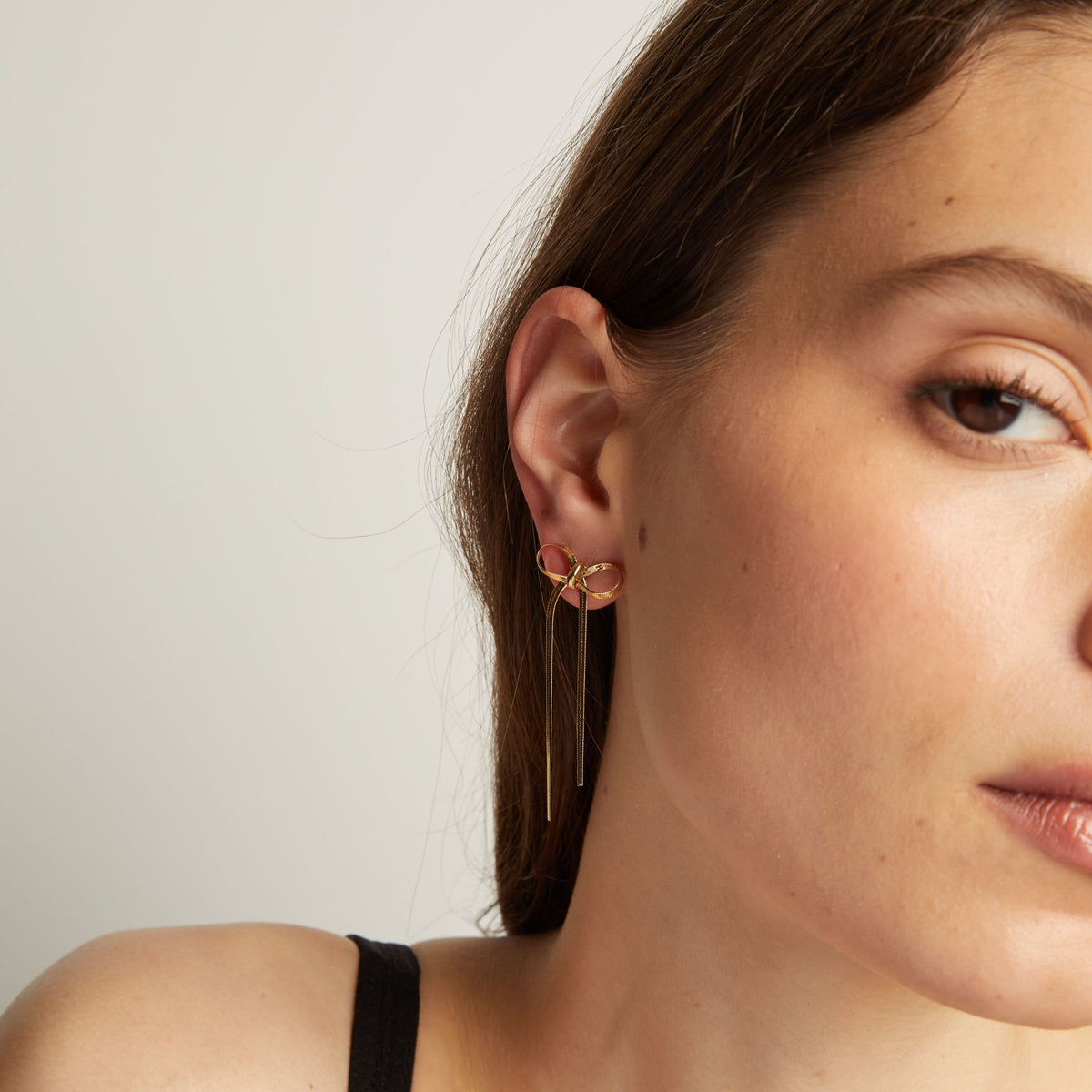 Model. Close up of woman wearing bow earrings. 
