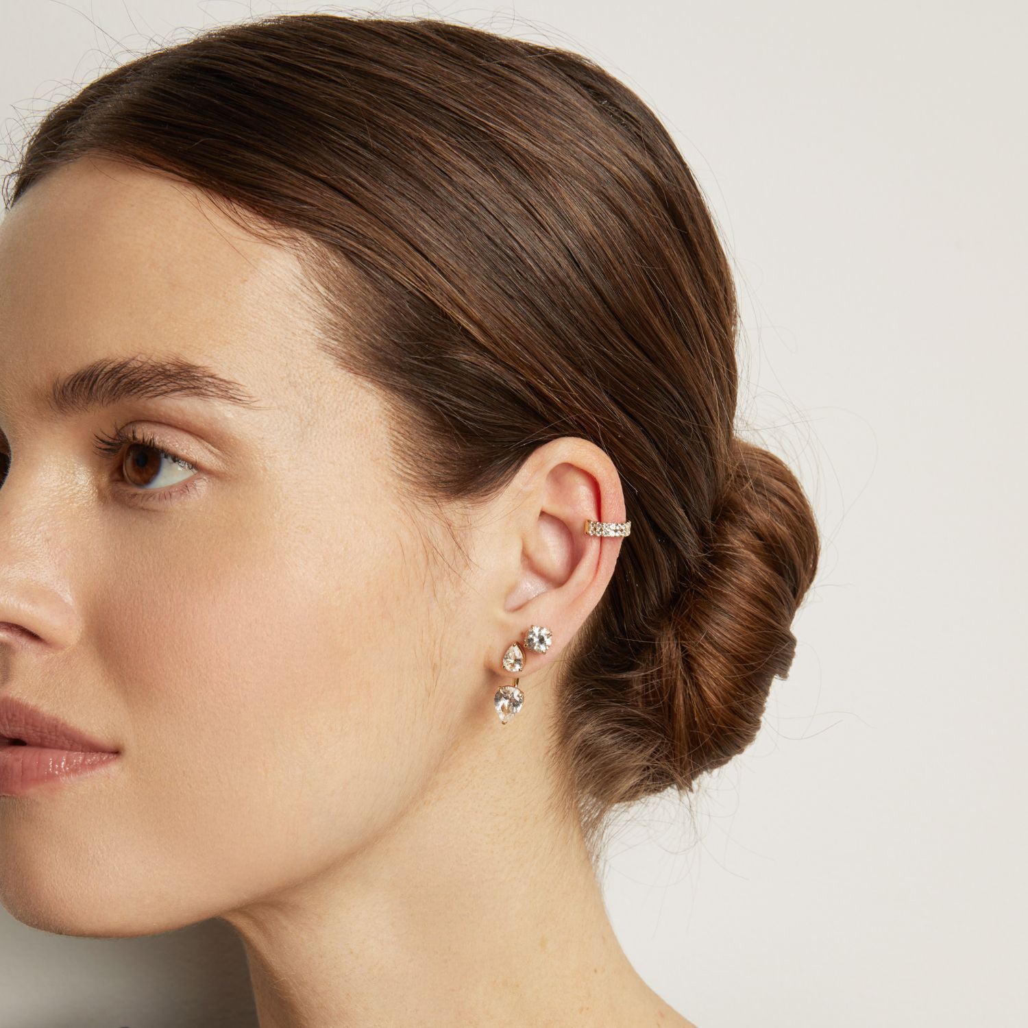 Model. woman wearing a diamond ear cuff and diamond earrings 