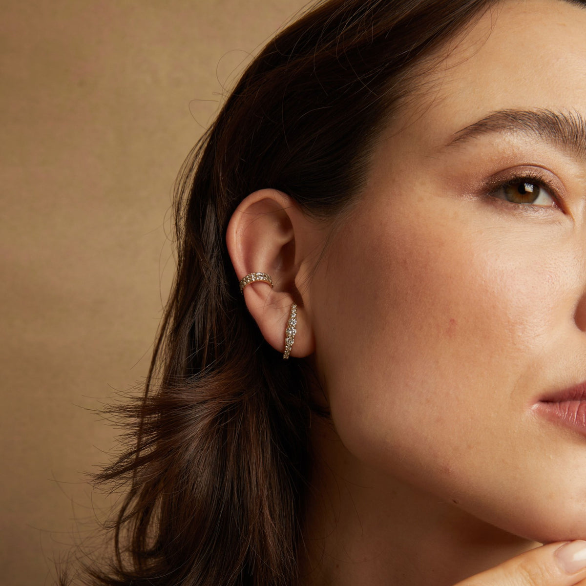 Model. Close up of woman wearing hoop earring and ear cuff