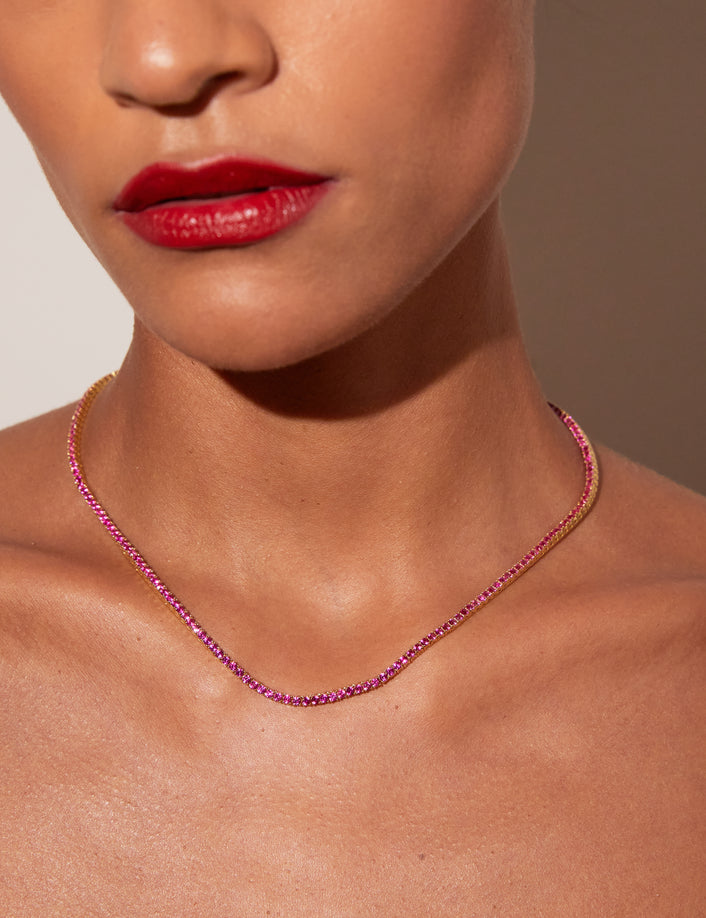 Model. Close up of a red tennis necklace on a woman