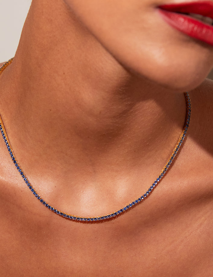 Model close up of woman wearing blue stone necklace 