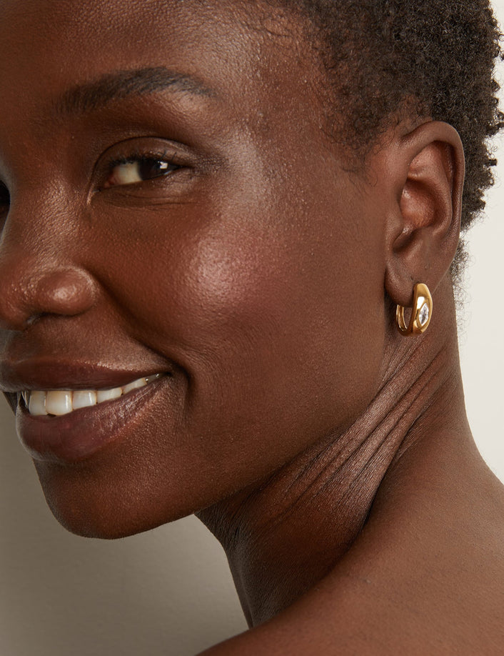 Model woman wearing gold earring 