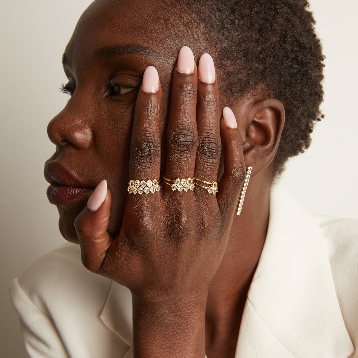 Model. Woman wearing various rings with white sapphire gemstones.