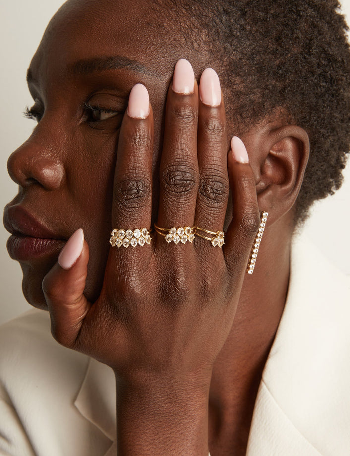 Woman wearing various rings with white sapphire gemstones.