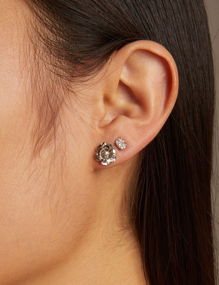 Close-up of a woman wearing earrings with a neutral background