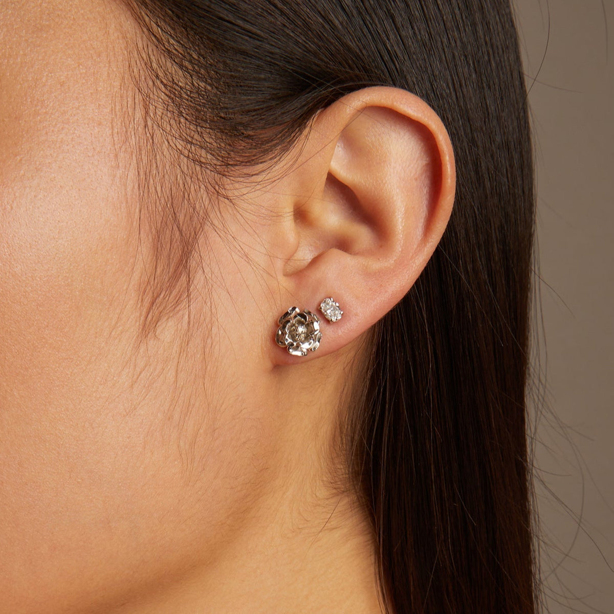 Close-up of a woman wearing earrings with a neutral background