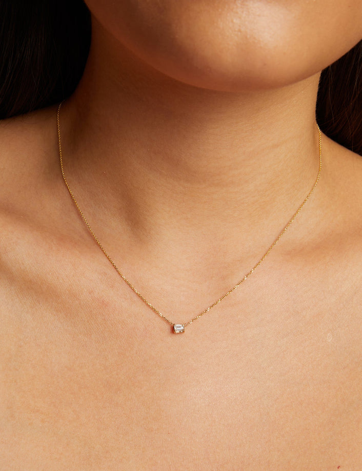 Model. Gold necklace with a small diamond pendant on a person