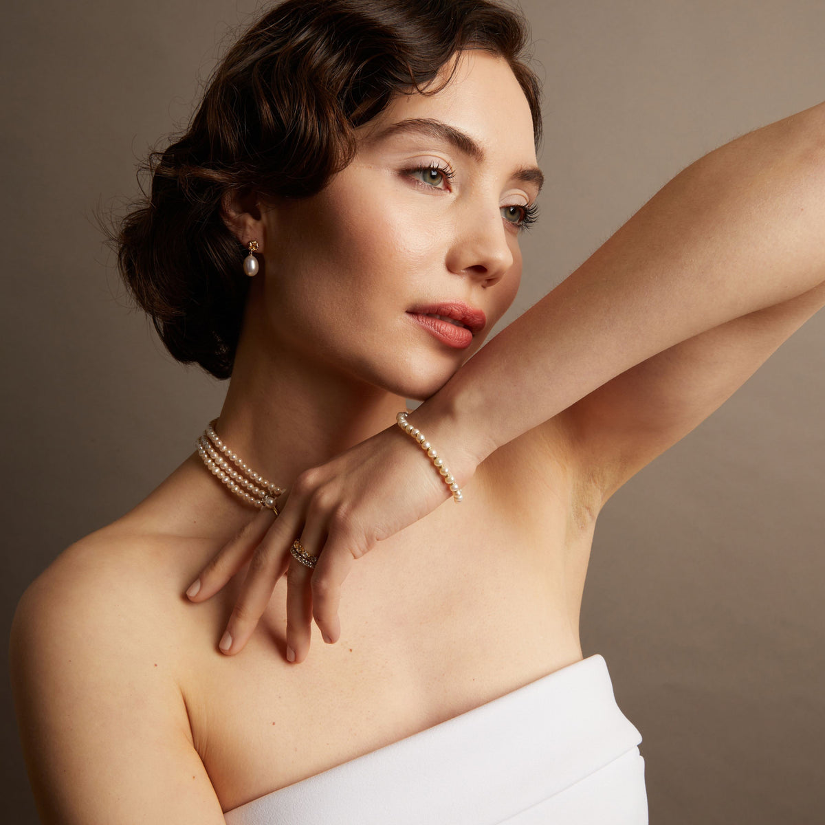 Model. Pearl knot bracelet and matching necklace on woman with her arm up.