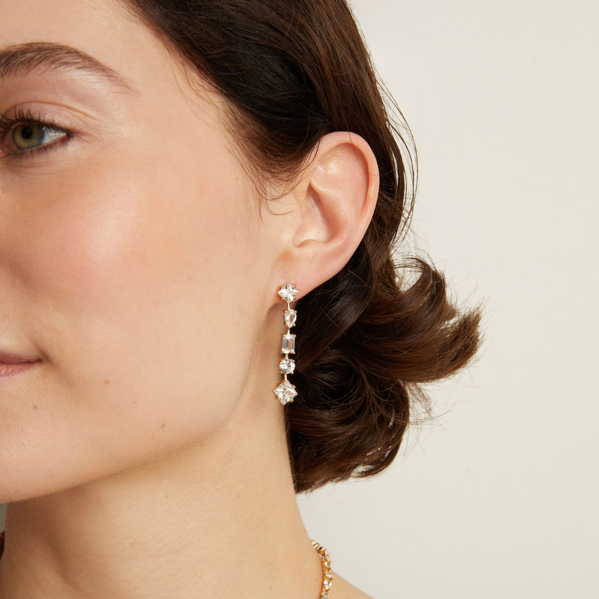 Model. Mixed shape tennis earrings on woman with neutral background.