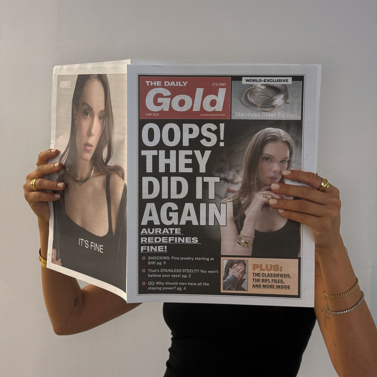 Model. Woman holding a tabloid over her face on a neutral background.