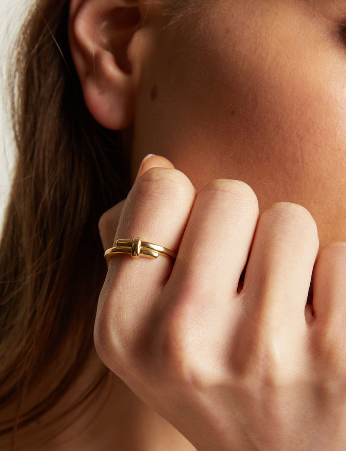 Close up of a person wearing a gold ring on their finger.