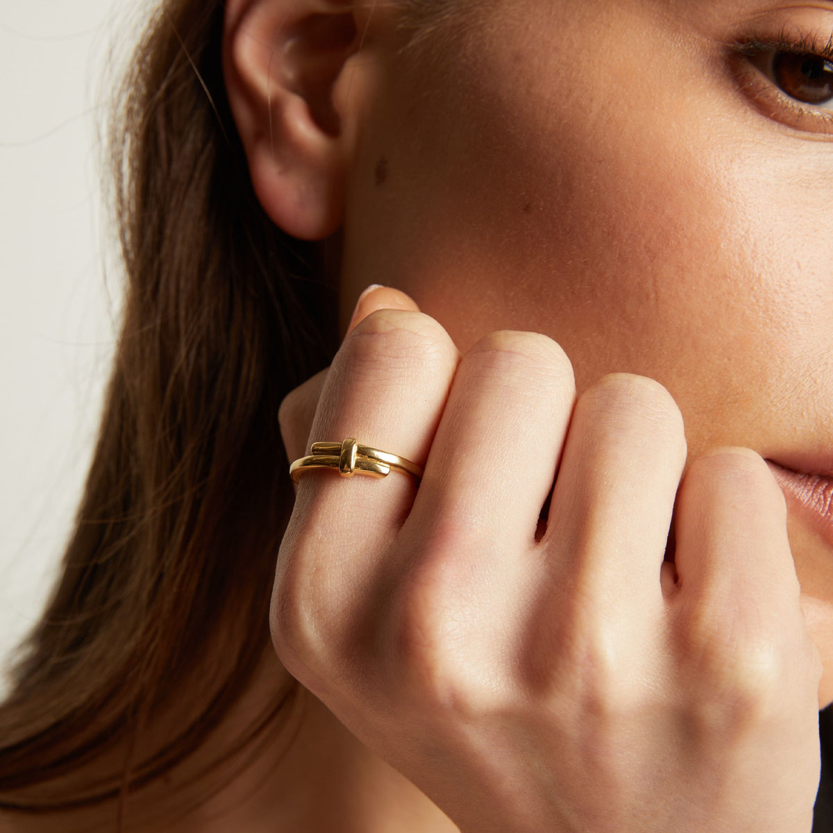 Close up of a person wearing a gold ring on their finger.