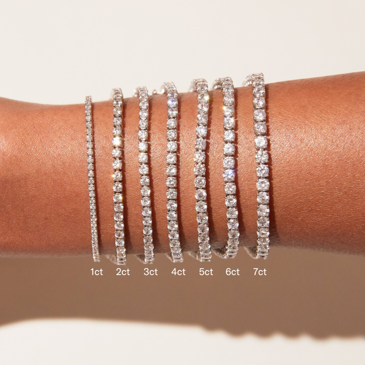 Model. Diamond bracelets of different carat weights on a wrist with measurements below.