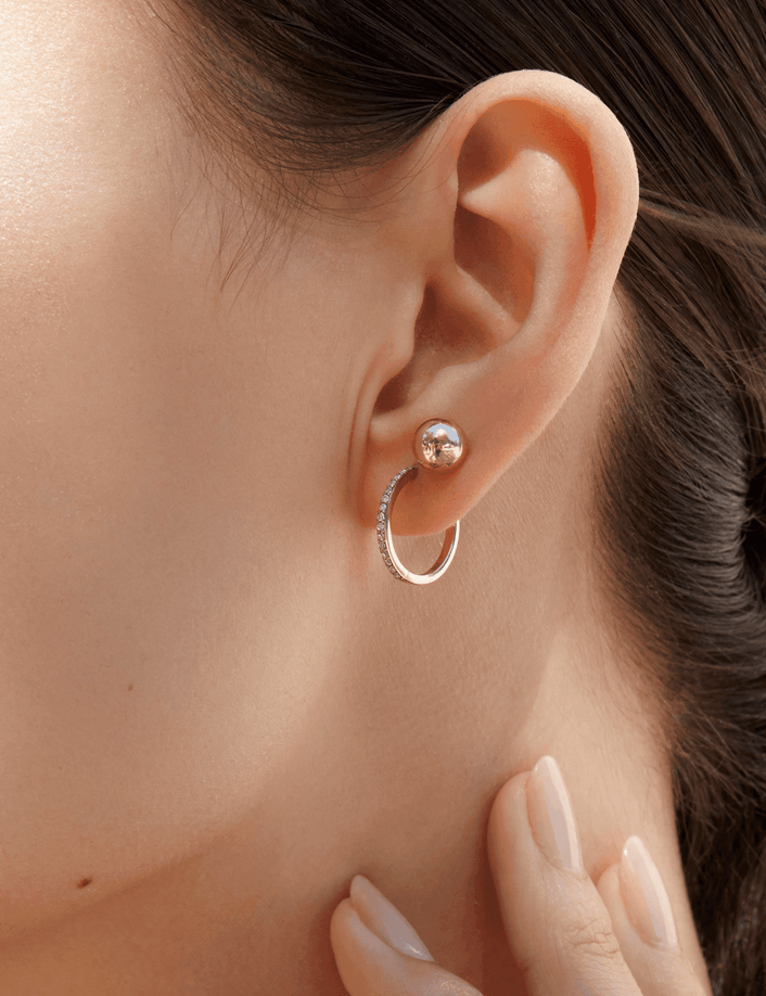 Lifestyle Model Close-up of a woman wearing a gold ball stud and a diamond hoop earring.