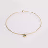 Video of gold collar necklace with gemstone pendant on white background.