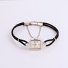 Video of a black rope watch with silver face with diamonds on white background.
