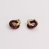 Video of a maroon and gold looped earrings on white background.