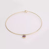 Video of gold collar necklace with gemstone pendant on white background.