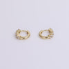 Gold huggie earrings with white sapphires on neutral background