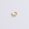 Gold huggie with gemstone on neutral background