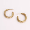 Video of gold hoop earrings on white background.