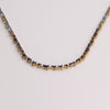 Video of blue tennis necklace on white background.