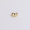 Gold ear cuff on neutral background.
